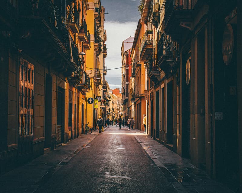 Eine schmale Straße in Barcelona mit Häusern und Balkonen auf beiden Seiten